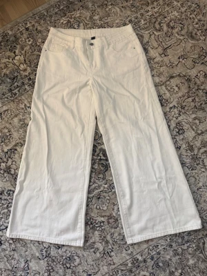 Vida vita jeans med låg midja - Säljer ett par snygga vita baggy jeans med låg midja och raka, vida ben. Perfekta till en trendig och avslappnad stil. Materialet är kraftig denim i bomull. Använda en gång.