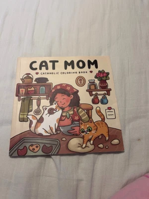 Cat Mom målarbok med kattmotiv - En söt målarbok med titeln 'Cat Mom' och charmiga illustrationer av katter och en kvinna i olika vardagssituationer. Omslaget är färgglatt med beige bakgrund och tecknade figurer. Perfekt för kattälskare som gillar att färglägga.