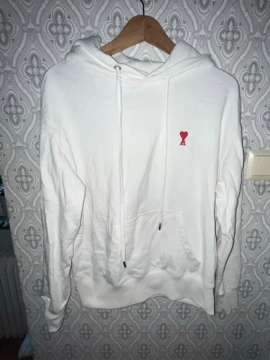 Ami Paris hoodie  - Ami Paris hoodie. Tyvvär har den fått defekter vid fickan när fastnade med den(går lätt att sy) och går även att använda som den är. KOLLA MÅTTEN NOGGRANT Längd 62cm, axelbredd 55cm Ö26