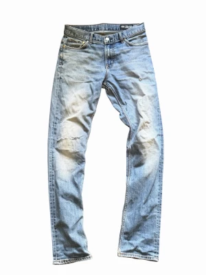 Crocker jeans med slitningar - Säljer ett par ljusblå jeans med raka ben och slitna detaljer på framsidan. Jeansen är tapered och i storlek 28/32. Skriv för funderingar