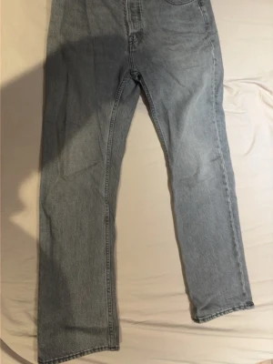 Acne Studios Ljusgrå raka jeans - Säljer ett par ljusgrå jeans med rak passform och klassisk femficksdesign. Jeansen har hög midja och är tillverkade i ett slitstarkt denimtyg. Perfekta för en avslappnad och trendig look.