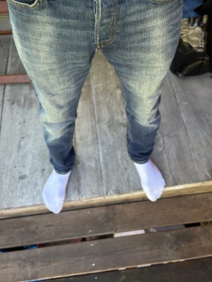 Mörkblå tapered jeans Jack & Jones - Snygga mörkblå jeans från Jack & Jones, modell Tapered/Erik. Klassisk femficksdesign med kontrastsömmar och en skön passform som smalnar av nedtill. Tillverkade i slitstarkt bomullsmaterial, perfekta för en avslappnad och trendig look.