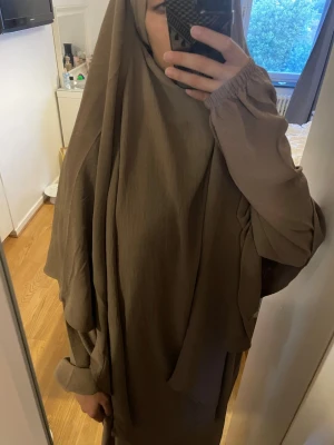Beige långklänning med vida ärmar - Säljer en enkel och modest beige långklänning med vida, långa ärmar och rund halsringning. Klänningen har en lös passform och är tillverkad i ett mjukt, fallande tyg som ger ett stilrent intryck. Använd ett fåtal gånger, passar alla storlekar och längder 155-165cm.