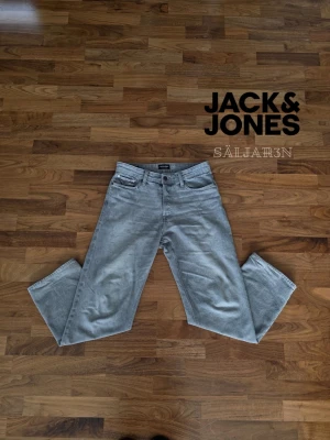 Grå Jack & Jones Jeans - Loose/Eddie - Jack & Jones Jeans Loose/Eddie Fit – Storlek W31/L32 – Mycket fint skick  Stilrena Jack & Jones jeans i modellen Loose/Eddie med modern loose fit-passform. Rymlig och bekväm modell som ger en avslappnad streetwear-look. Jeansen har en snygg ljusgrå tvätt som passar perfekt till både vardag och mer trendiga outfits.  ✅ Märke: Jack & Jones ✅ Modell: Loose/Eddie ✅ Storlek: W31 / L32 ✅ Färg: Ljusgrå ✅ Passform: Loose fit ✅ Skick: Mycket fint skick  📦 Snabb leverans – skickas samma dag (om ej hindr.)