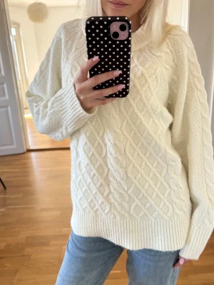 Vit stickad tröja - Mysig vit stickad tröja med rund halsringning. Tröjan har ett flätmönster och är lite oversized i modellen. Perfekt för kalla dagar och enkel att styla med jeans🤍. Skriv för mer info