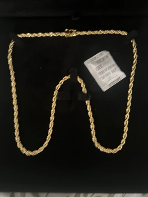Guldplänterat cordel 18k - Säljer ett snyggt  halsband med tvinnad design. Halsbandet har en klassisk kedja som ger en exklusiv känsla och passar perfekt till att lyfta vilken outfit som helst. Materialet ser ut att vara metall med guldfinish och halsbandet har ett smidigt lås.