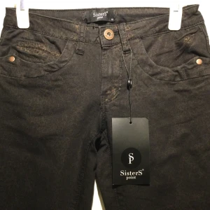 Svarta Jeans med tryckt djurmönster i guld Sisters Point Strl: XS - Jättefina svarta jeans från Sisters Point i storlek XS. Modellen har ett unikt och coolt tryckt djurmönster i guld som ger en lyxig känsla. Perfekta till både vardags och fest  🏷️ Sisters Point 👖XS (34) 🔎 Nytt oanvänt med tags 📌 Guldtryck, djurmönster / animal print 🚭   Samfraktar självklart om du hittar något mer i min garderob!  Inga bilder när den sitter på mig! Katter finns i hemmet