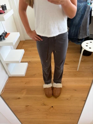 Grå mjukisbyxor från gina tricot - Gråa mjukisbyxor från gina tricot i storlek XXS. Uppsydda och använda men fint skick. Materialet sammet med knyt band runt midjan.