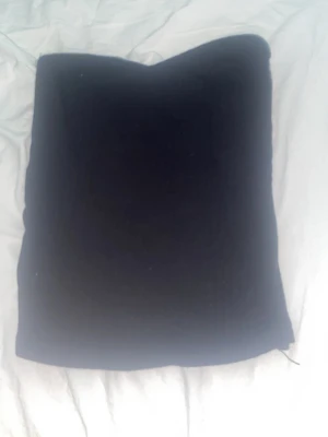 Svart tubtopp med ribbat material  - En enkel svart tubtopp i mjukt material. Perfekt att styla med olika accessoarer och passar till många olika looks. Klassisk och tidlös design utan axelband.