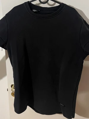 Svart sweatshirt med vita detaljer - En oversized svart sweatshirt med vita blockdetaljer på ärmar och nedtill. Tröjan har rund halsringning och långa ärmar. Perfekt för en avslappnad och trendig stil. m men passar även L och XL. Pris kan diskuteras vid snabb affär.