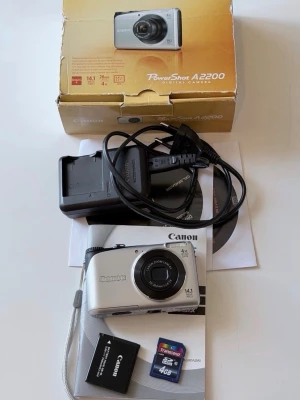 Canon PowerShot A2200 digitalkamera - Canon PowerShot A2200 är en kompakt digitalkamera i silver med 14,1 megapixlar, 4x optisk zoom och 28mm vidvinkelobjektiv. Kameran har en stor LCD-skärm, levereras med laddare, batteri, handledsrem och 4GB SD-kort. Perfekt för dig som vill ha en smidig kamera.