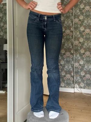 Nelly jeans med detaljer  - Säljer ett par mellanblå bootcut jeans från Nelly med låg midja. De har en riktigt skön passform då de är mycket stretchiga. De är lite slitna längst ner vid hälen, men inget man tänker på särskilt mycket❣️