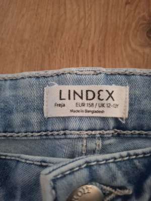 Ljusblå jeans från Lindex Freja - Säljer ett par ljusblå jeans från Lindex, modell Freja. Jeansen har raka ben och klassisk femficksdesign. Tillverkade i ett mjukt denimtyg som är skönt att bära. Perfekta för dig som gillar en avslappnad och stilren look.