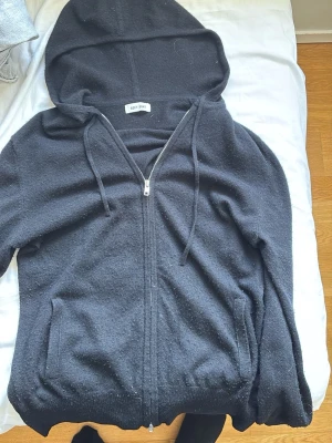 Soft goat hoodie - Kashmirhoodie från Soft Goat i svart med dragkedja framtill, två fickor och justerbar huva. Mjuk och lyxig känsla, perfekt för chill dagar. Ribbstickade muddar vid ärmslut och nederkant. Enkel och stilren design som passar till det mesta. Jätte bra skick och super skön. Köpt i butik för 2999 men priset höjs 