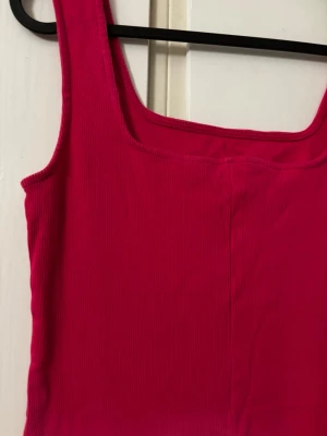 Rosa ribbad långklänning - Säljer en snygg rosa långklänning med ribbad struktur och ärmlös design. Klänningen har en rak passform och fyrkantig ringning, perfekt för dig som gillar enkel men trendig stil. Den bästa passar även de som har stl M. Köpt i Turkiet.