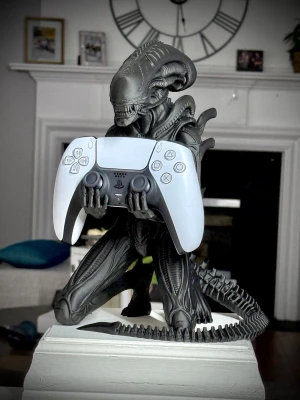 Alien hållare för spelkontroll - Snygg hållare i form av en Alien-figur, perfekt för att förvara din spelkontroll. Tillverkad i svart plast med detaljerad design inspirerad av Alien-filmerna. Passar utmärkt till PS5 DualSense och andra handkontroller.