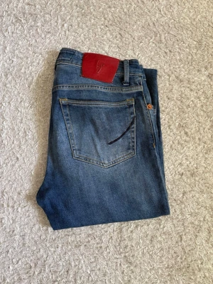 Handpicked Ravello-C Jeans - Handpicked Ravello-C jeans tillverkade i Italien. Sparsamt använda och i mycket bra skick utan hål eller slitage.  Premiumjeans med stretch, röd läderpatch baktill och detaljer på bakfickorna. Säljs då de blivit för små för mig.  📦 Snabb leverans! 💬 Hör gärna av dig vid frågor eller om du vill ha fler bilder/mått!