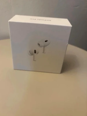  Apple AirPods Pro hörlurar - Säljer ett par Apple AirPods Pro i originalförpackning. Trådlösa in-ear hörlurar i vit färg med stilren och kompakt design. Perfekta för musik, samtal och träning. Levereras i snygg vit kartong.