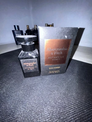 Abercrombie & Fitch Authentic Night - Abercrombie & Fitch Authentic Night är en herrparfym i en elegant, mörk glasflaska med svart lock. Förpackningen är svart med en kopparfärgad etikett och text. Flaskan rymmer 50 ml Eau de Toilette och har en stilren, maskulin design som passar perfekt i badrumshyllan. Orginal förpackning tillkommer. Kolla bild för mängd kvar.