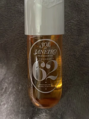 Sol de Janeiro Cheirosa 62 Parfym - Sol de Janeiro Cheirosa 62 är en parfym mist i en genomskinlig, bärnstensfärgad plastflaska med vit kork. Doften har inslag av pistage, salt karamell och vanilj. Flaskan har en modern, rundad form och tydlig märkning framtill.