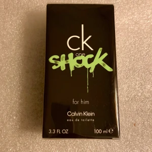 *NY*ck one Edt ”SHOCK”, 100 ml  - Ny i inplastad kartong.  CK One Shock for him inleds med uppfriskande noter av saftig clementin och krispig gurka.  Hjärtnoterna pulserar med svartpeppar och kardemumma tillsammans med svart kryddig basilika. 