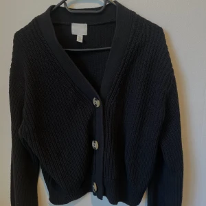 Ribbstickad kofta - Svart ribbstickad kofta med knappar, storlek xs från H&M. Använd ett fåtal gånger, bra skick!✨