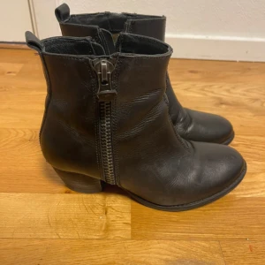 Klackskor - Skor med klack De är väl använda , alltså lite slitna i klacken man ser att de är använda.  Rätt dyra från början men säljer billigt så de är använda  Det finns två dragkedjor, den ena går att öppna och den andra är till för ”pynt”