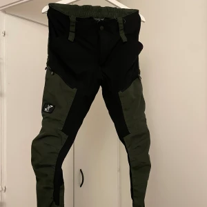 RevulotonRace Friluftsbyxa  - RVRC GP PANT DAM. Forest Green  Storleken stämmer sådär. Tyget är stramt för slitstarkhetens skull, så har man mellan stl S/M och är lite längre tror jag dem passar prima!  Fint skick och knappt använda  Nypris: 799:-