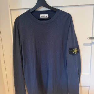 Stone Island tröja - Säljer en blå Stone Island tröja. Knappt använda så i nyskick. Storlek XL men lite i storlek så passar L.