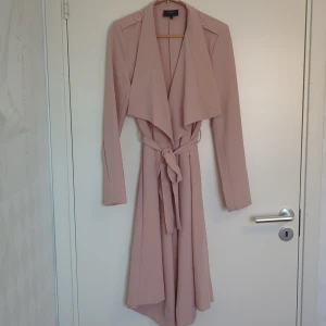 Rosa kappa - .Object - Rosa tunn kappa från .Object, strl S.  Har haft axelvaddar men föregående ägare har klippt bort dem. Köpt second hand, aldrig använd av mig. I bra skick, utöver en fläck bak på höger axel (jag har inte försökt ta bort den).  Superfin sommarkappa! ✨