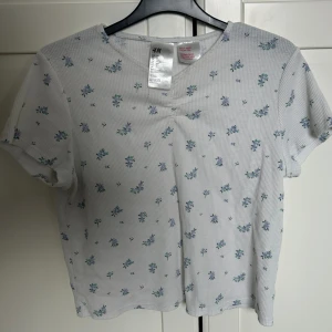 Vit tröja med jätte fina blåa blommor! 💕 - Den har använts några gånger men inga fel eller fläckar. Super fin nu till sommaren 