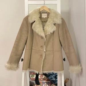 Jacka med pälskrage - Jättefin beige jacka med fuskpälskrage. Är i perfekt skick. Passar storlek M/L beroende på vilken passform man vill ha. 