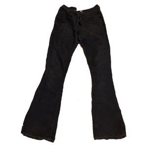 Söta mörkgråa midwaist bootcut jeans - Ganska använda och har ett pyttelitet ihoppsytt hå vid innersidan av låret som knappt syns.