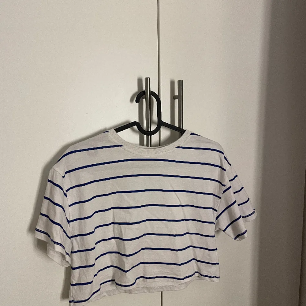 Säljer nu min randiga t-shirt från Kappahl då den inte kommer till användning! Det är en vit tröja med blåa sträck/linjer!💙 Väldigt fint skick! Den är i storlek 146/152 men är som en xs!. T-shirts.