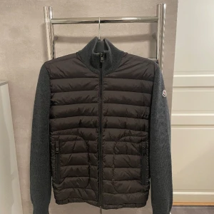 Moncler Cardigan - Tja, säljer denna feta cardigan i storlek M, den är i riktigt bra skick, 9/10!  P2P på jackan är 46Cm, färgen är grå! 