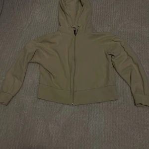 En kort ziphoodie - Den är kort, inte så tjockt material, är kort kommer ungerske upp till magen. Beige färg. Storleken går både för S och XS
