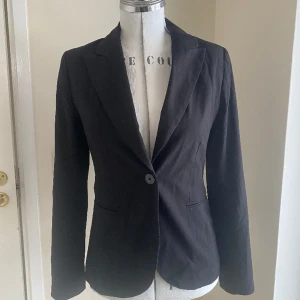 Svart kavaj, stl 36 - Snygg svart kavaj i klassisk modell. Randig på insidan. Fint använt skick.  Kommer från djur och rökfritt hem.  Passar både fest, arbete och till vardags. 