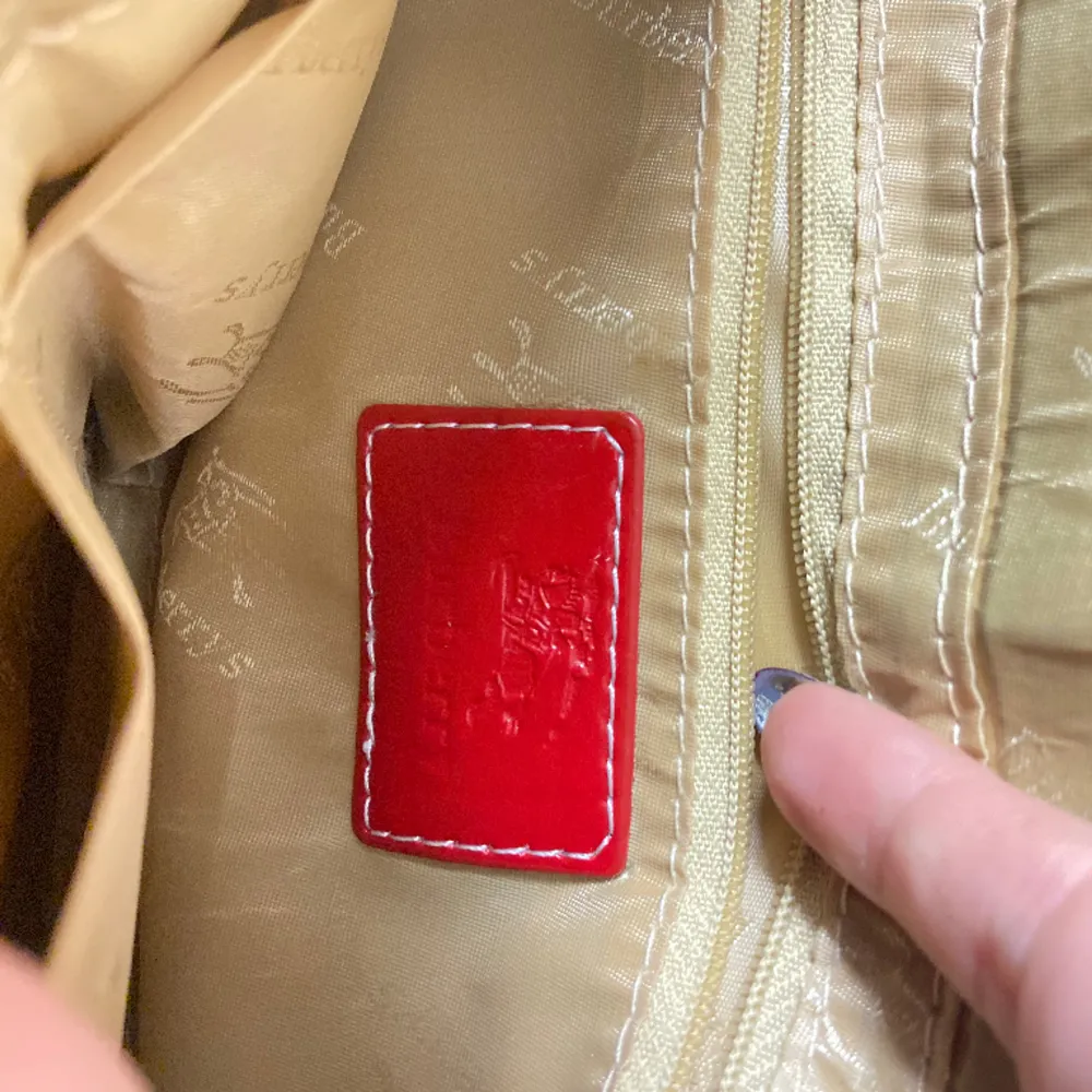 Oklart om väskan är äkta eller inte men den är fortfarande väldigt snygg. Lite sliten på dom röda läder banden se första bilden.. Väskor.