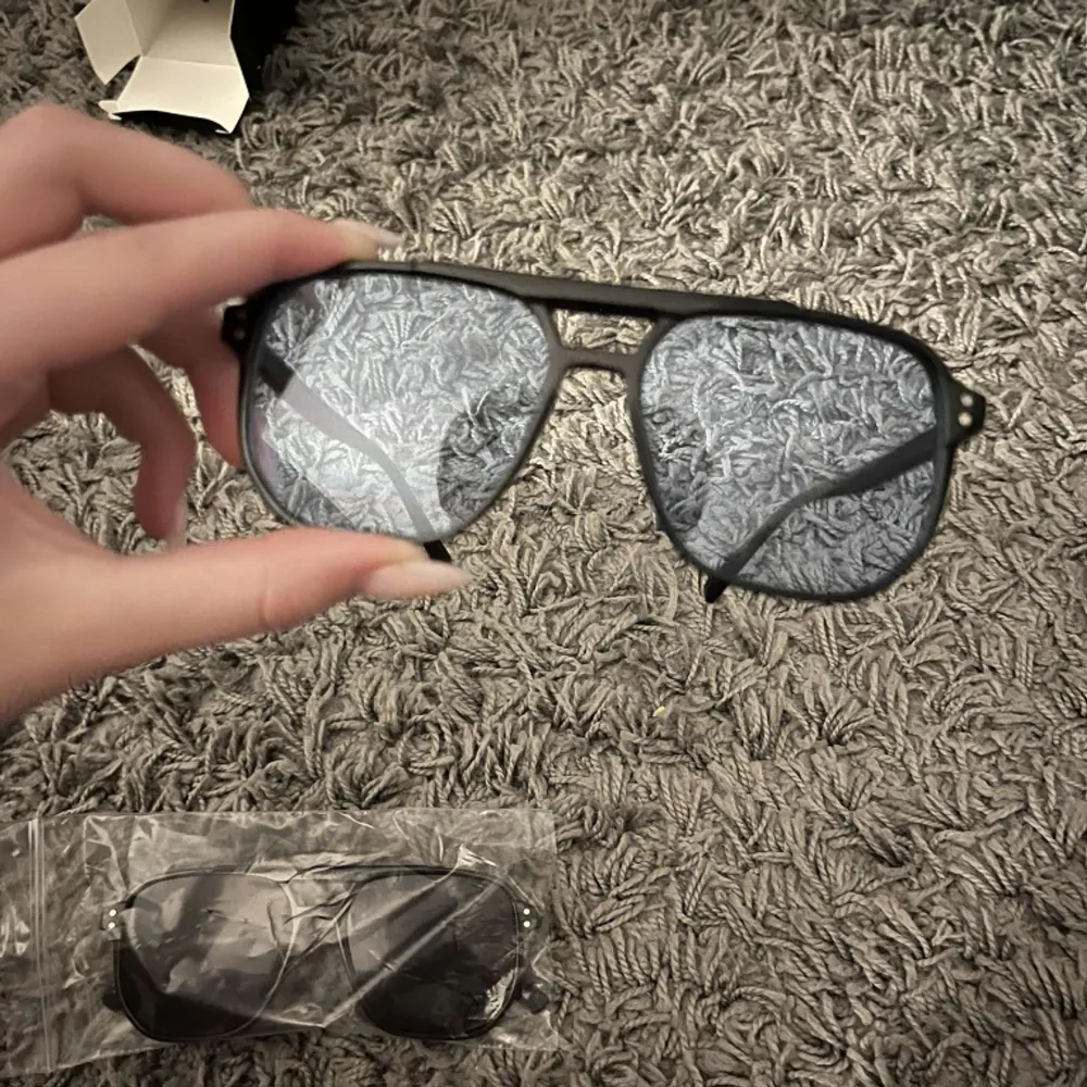 Solglasögon från Ensaroje med blått glas, helt oanvända och förpackning samt tvätt till glaset medföljer.. Accessoarer.