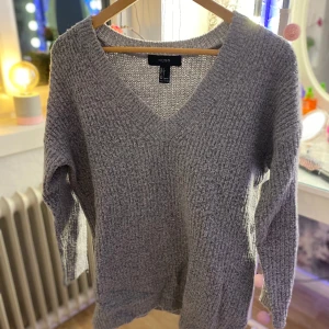 Stickad tröja - En grå fin tröja, mönster på framsidan av tröjan, baksidan är det inget mönster. Väldigt fin skick 