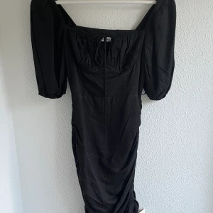 Adoore Palermo klänning - Svart klänning från Adoore i modellen Palermo. Helt ny med prislappar kvar. Storlek 34/XS men passar även en 32/XXS. Justerbart band på sidan så längden kan ändras