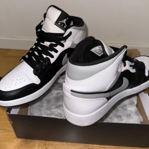 Air Jordan 1 Mid (black/white/grey)  - Air Jordan 1 Mid (black/white/grey) väldigt eftertraktade som är svåra att få tag i. Endast använd en gång. I princip helt nya. Storlek 43.