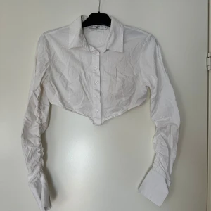 Croppad skjorta - En croppad skjorta med detaljer på ärmarna. Använd 1-2 ggr.
