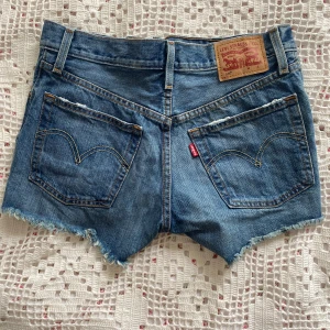 Jeansshorts Levis  - Jeansshorts från Levis💫 lite slitna som syns på bilderna men så fina!! Säljer eftersom de är lite små för mig, jag är vanligtvis W27-28 och dessa är W25, omkrets 70cm! Passar nog en XS