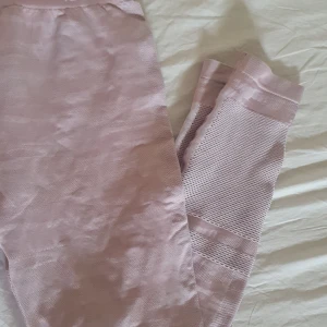 Rosa träningsbyxor - Rosa med lite nyans skillnader. Andningshål vid smalbenen. Hård risår runt magen så sitter bra och åker ej ner.