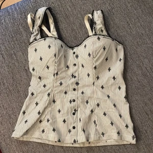 Fin korset linne - Väldigt fint linne som har en inbyggd bh i som är väldigt skön och bekväm! Älskar detta linnet men den har tyvärr blivit för liten för mig så tänkte att någon annan ska få njuta av detta vackra linnet. Storlek 75C på Bh:n. Går att justera på bh band.