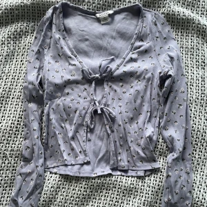 Lila kofta med knytdetalj - Lila blommig kofta med knytdetalj och blommor