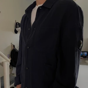 CP. Company overshirt  - Tjena, säljer denna feta overshirt från Cp. Company!🍾  Skick 10/10 då den aldrig kommit till användning. Passar perfekt till sommarkvällar.  Storleken är L men passar utmärkt till M, modellen är 177cm, 77 kg. Nypris: ca 4000 kr Mitt pris: 1199 kr🔝