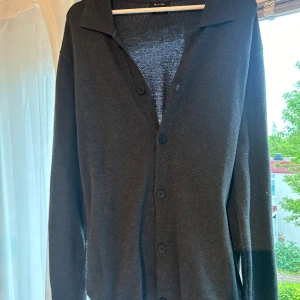 Kofta, Massimo dutti - Rensar ur garderoben inför kommande flytt, därav en massa grejer som ska säljas. Grå kofta från Massimo dutti med svarta knappar framtill. Endast använd enstaka gånger och i jättefint skick.