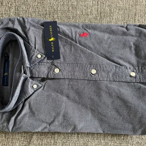 Grå Ralph Lauren Skjorta - Fin Ralph Lauren skjorta. Ny utan prislapp. Populär bland tjejerna. Storlek: S  Pris 250kr